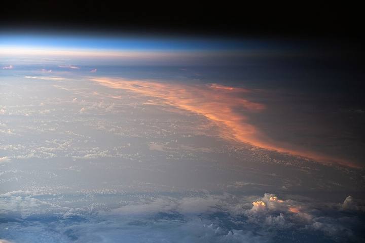 Fotografia da Estação Espacial mostrando a passagem do dia para a noite sobre as nuvens