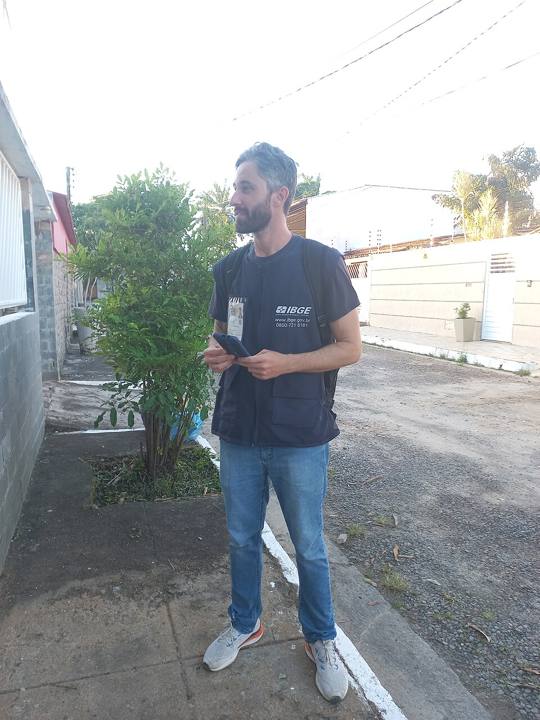 Recenseador do IBGE com o colete e o equipamento do censo