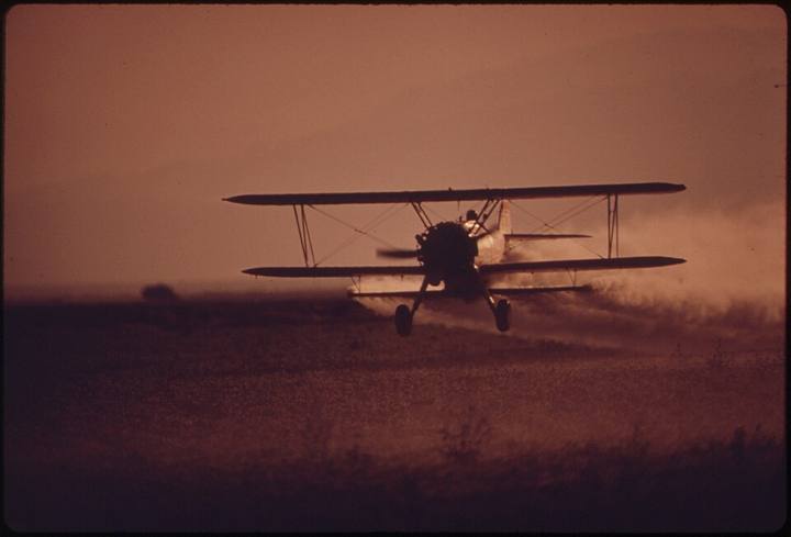Avião agrícola pulverizando uma lavoura